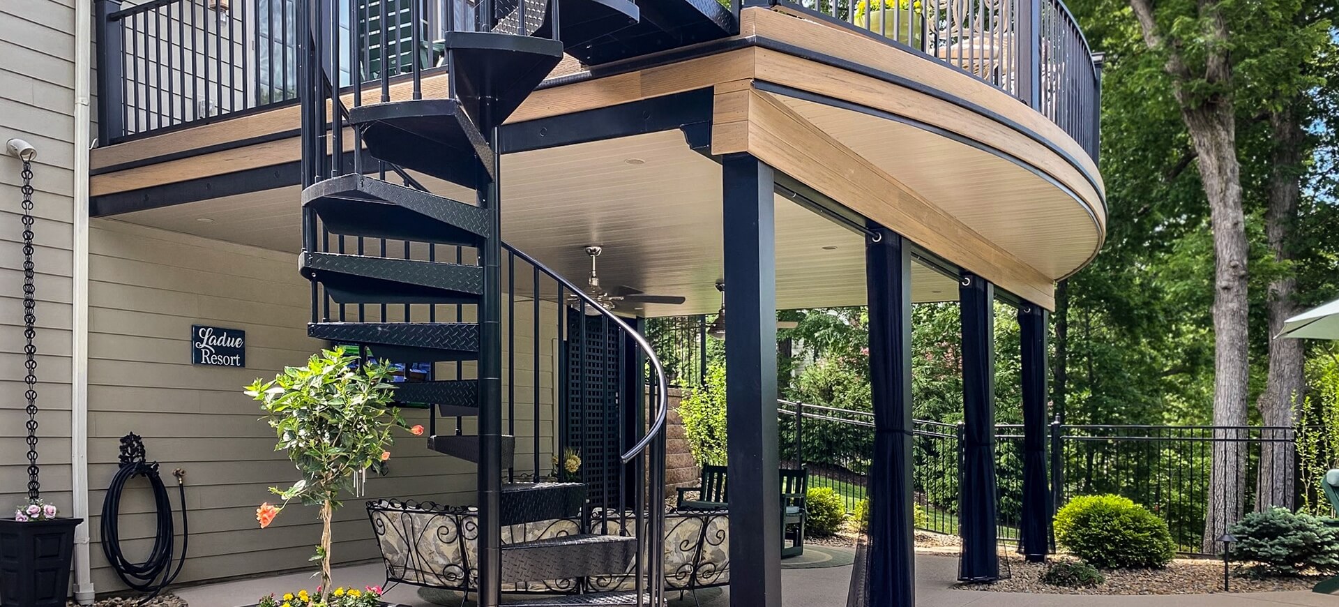 beige under deck ceiling provides contrast with black iron spiral staircase and black deck columns